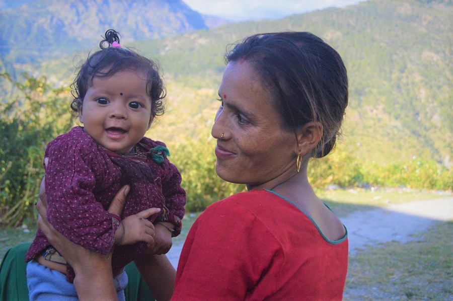 Mother holding child in mountainous background